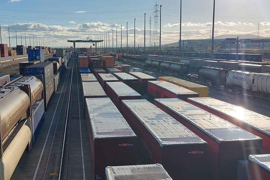 © ÖBB/Papp Zahlreiche beladene Frachtzüge, im Hintergrund ist ein Portalkran zu sehen.